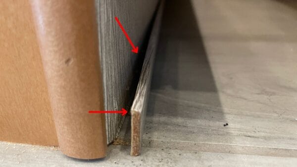 A trim piece on the baseboard that is pulling away from the wall